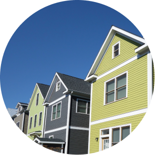 Colorful row houses with yellow and gray siding under blue sky