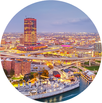 Aerial view of Baltimore Inner Harbor at dusk with illuminated skyscrapers